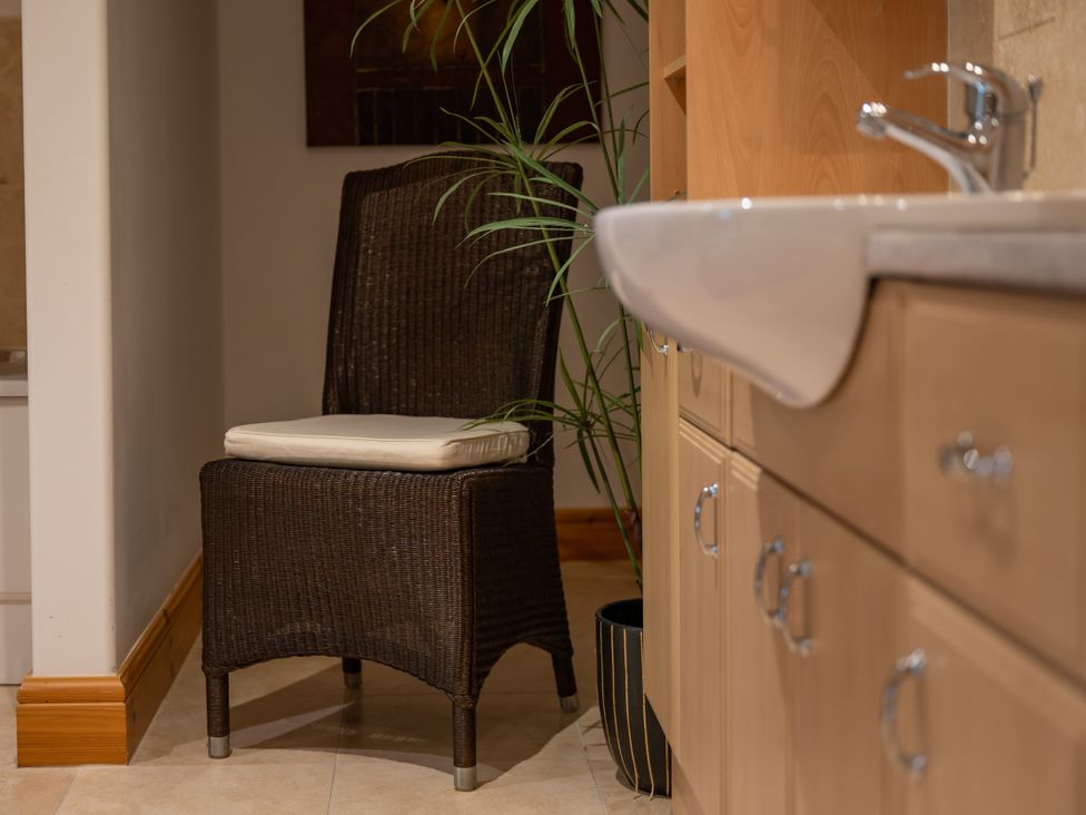 A bathroom with a chair and sink at Old Distillery Lodge