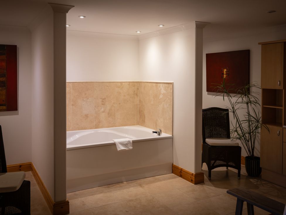 A bathroom with a bathtub and a plant at Old Distillery Lodge