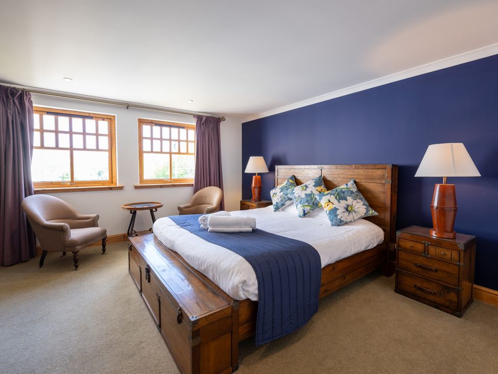 A bedroom with a bed, nightstand, and chairs at Old Distillery Lodge