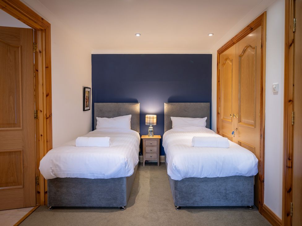 A bedroom with two single beds and a nightstand at Old Distillery Lodge