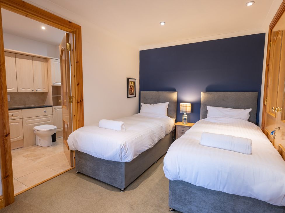 A bedroom with two beds and a nightstand at Old Distillery Lodge