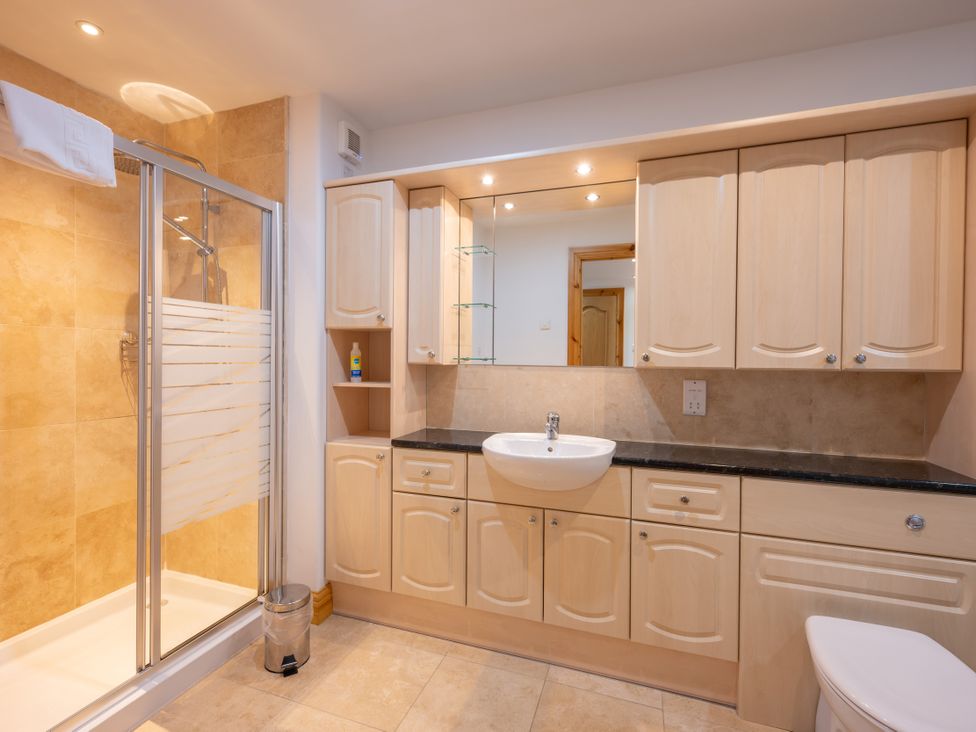 A bathroom with a shower, sink, and toilet at Old Distillery Lodge