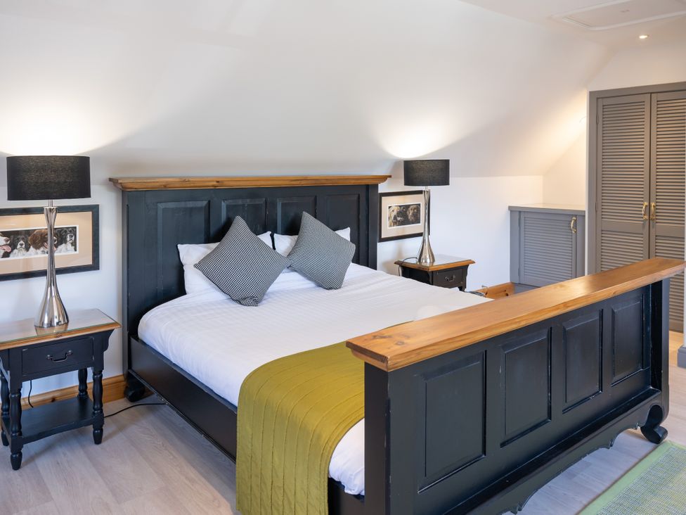 A bedroom with a king-sized bed and bedside tables at Old Distillery Lodge