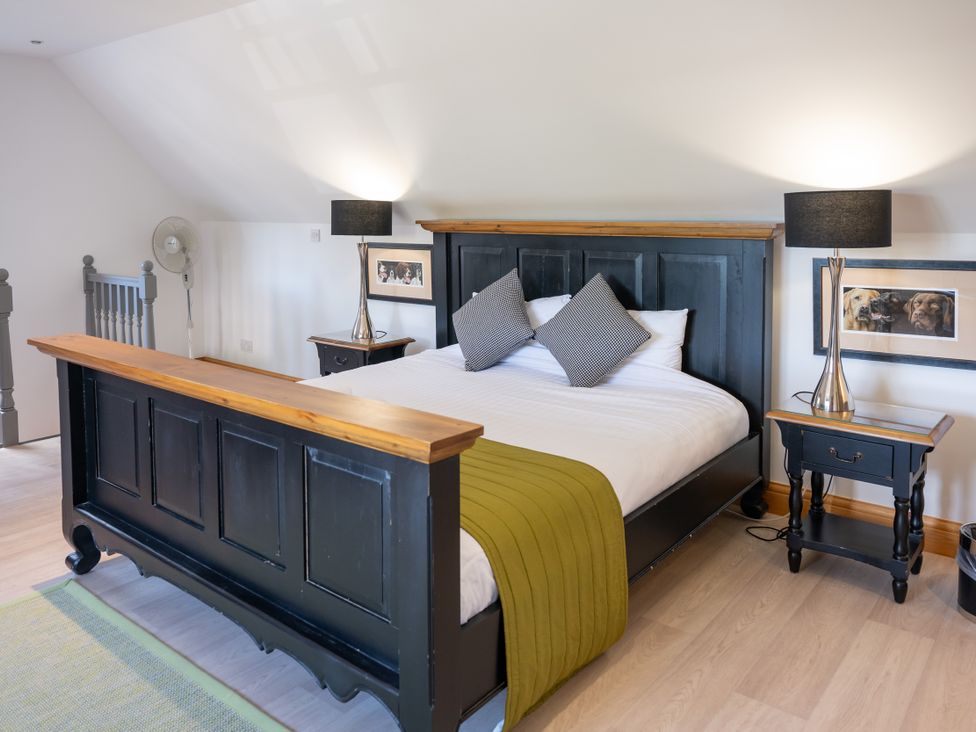 A bedroom with a black bed frame and nightstand at Old Distillery Lodge