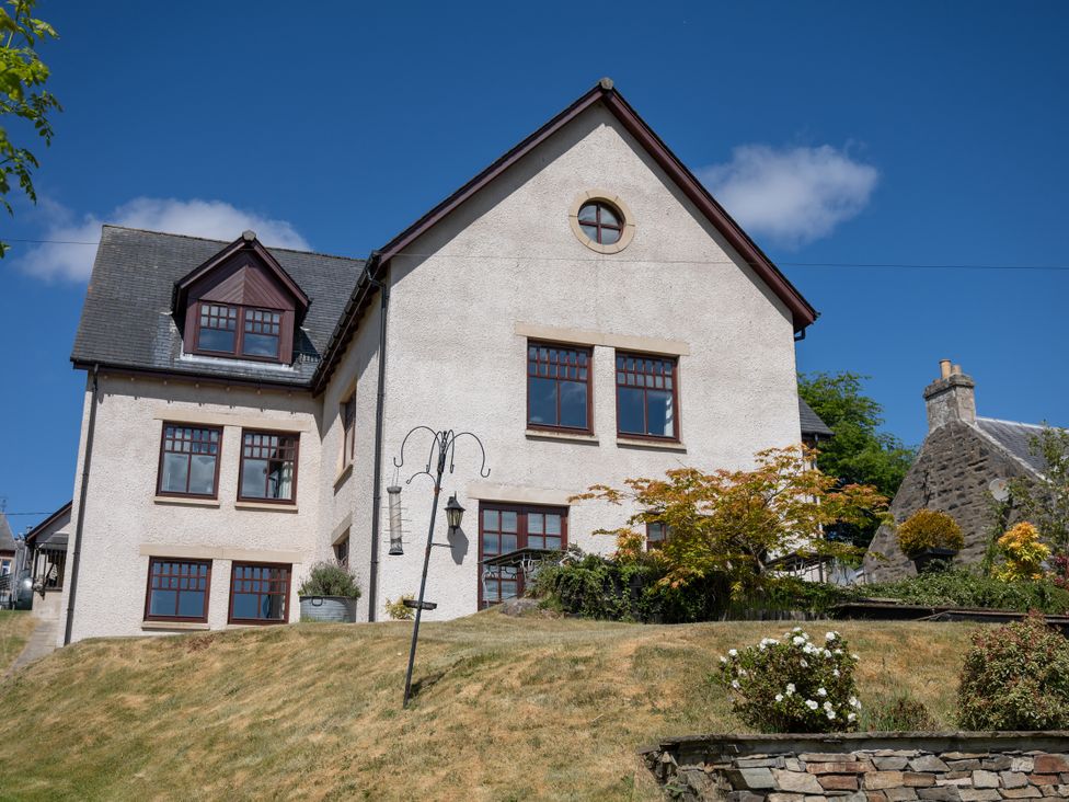 An exterior view of a house with a lawn and lamps at Old Distillery Lodge