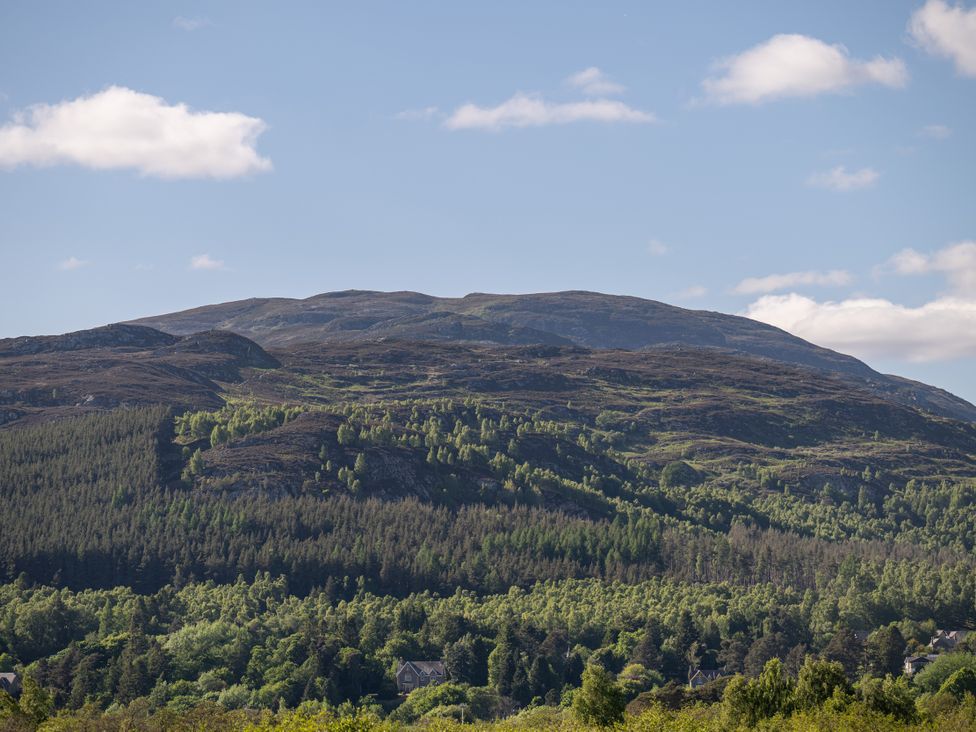 A landscape featuring a mountain with trees and houses at Old Distillery Lodge