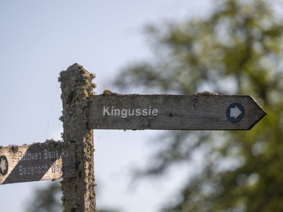 A wooden sign pointing to Kingussie and Ruthven Barracks on Badenoch Way at Old Distillery Lodge