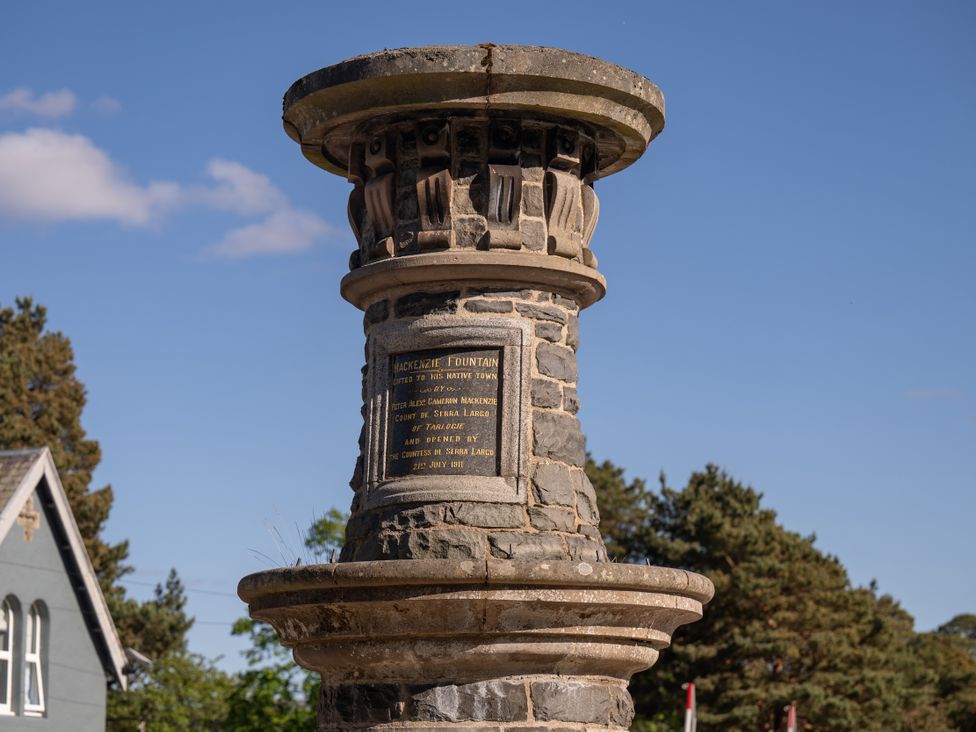 A stone fountain with a plaque dedicated to Mackenzie in a town
