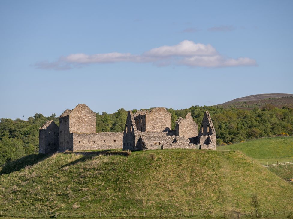 Ruins on a hill with trees and a blue sky at Old Distillery Lodge in 