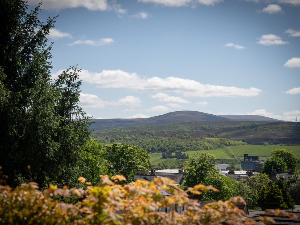 A view of hills and greenery with trees in the foreground at Old Distillery Lodge