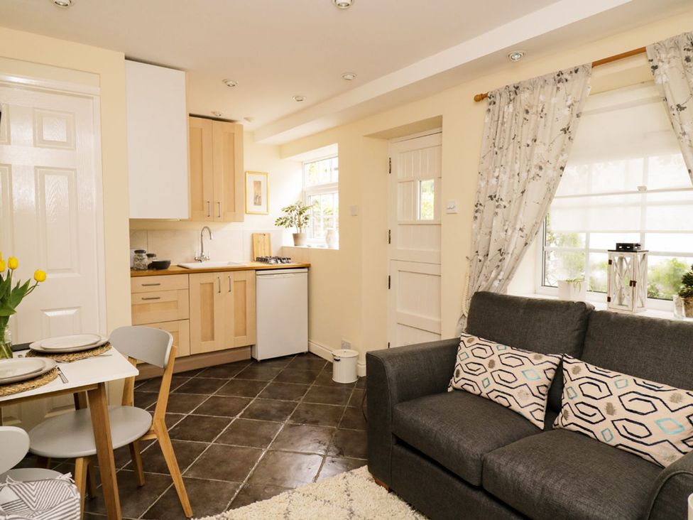 A kitchen with a couch and dining area at Figgy Cottage in Ripon