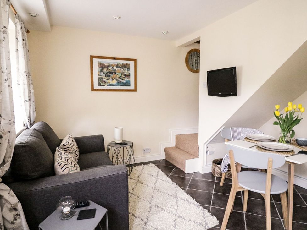 A living room with a sofa, dining table and chairs at Figgy Cottage in Ripon