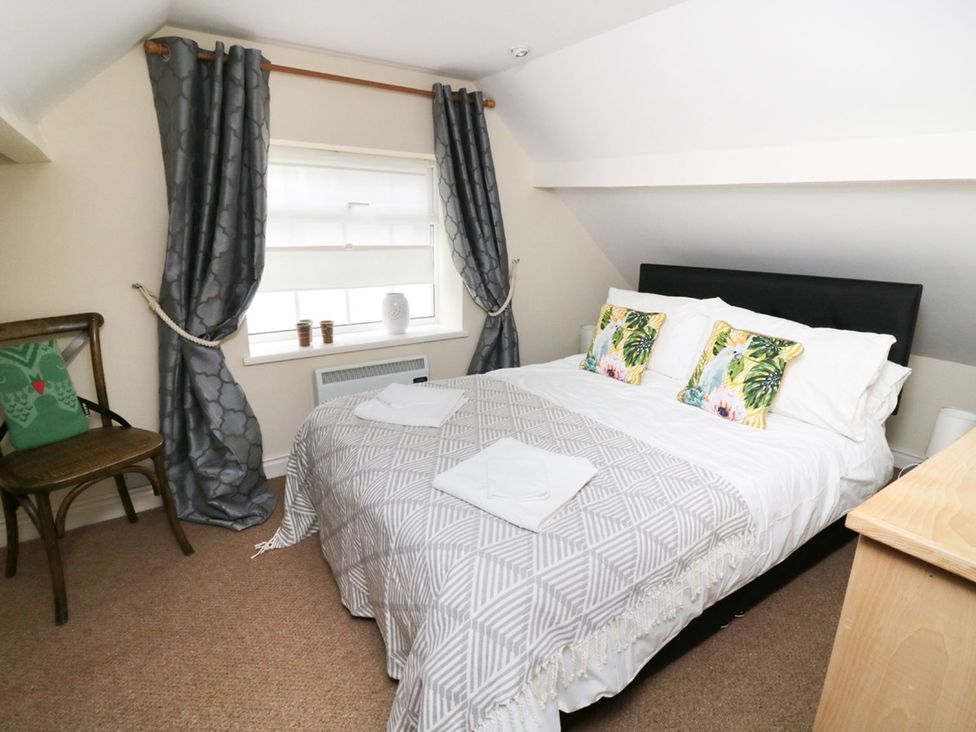 A bedroom with a bed and window at Figgy Cottage in Ripon