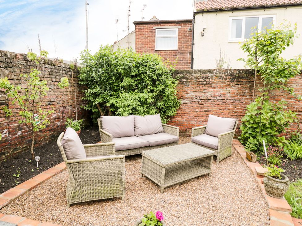 A garden with seating area and plants at Figgy Cottage in Ripon