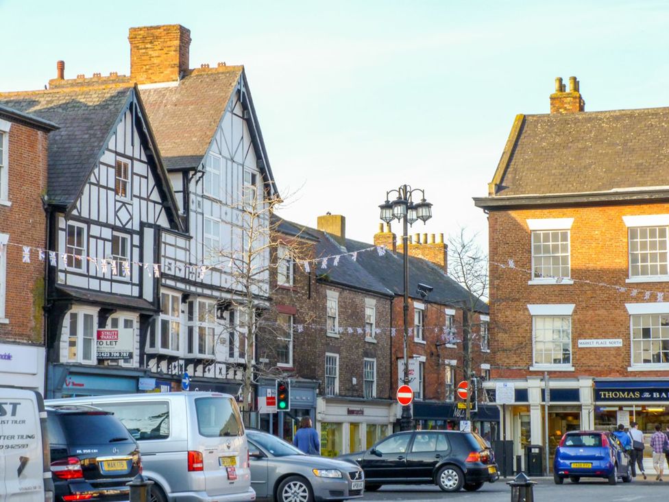A street view with buildings and vehicles at Figgy Cottage in Ripon