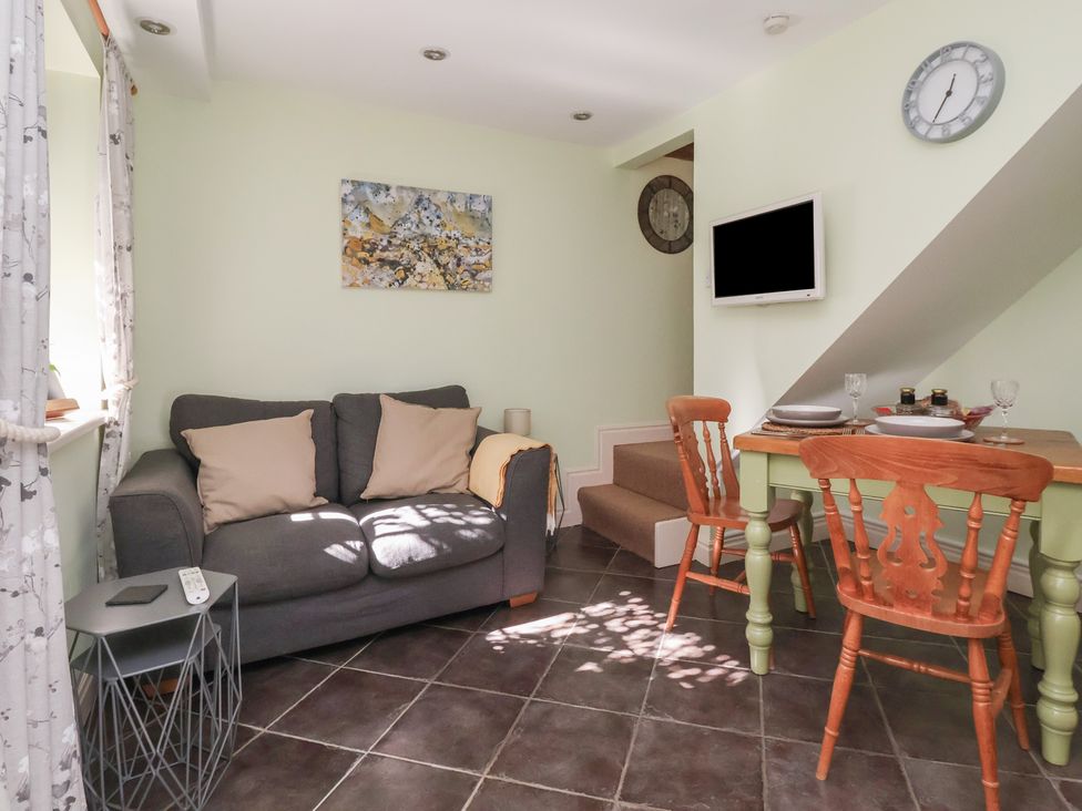 A living room with a sofa and dining table at Figgy Cottage in Ripon