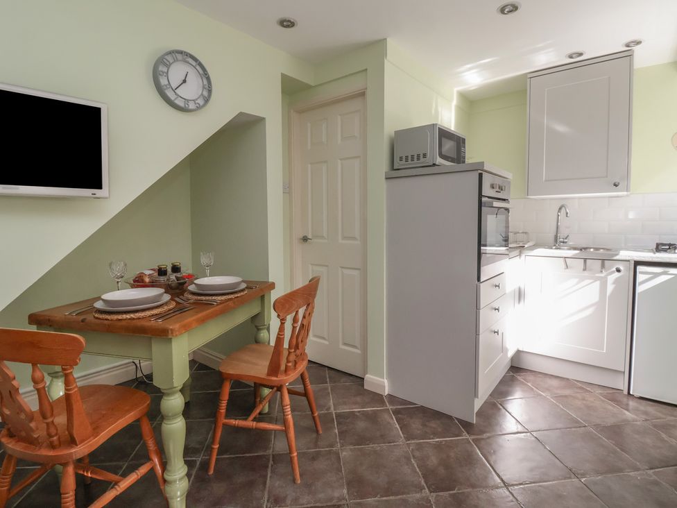 A kitchen with a table and chairs at Figgy Cottage in Ripon