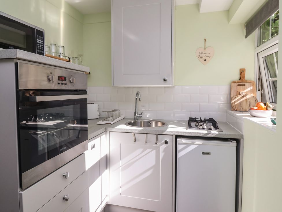 A kitchen with appliances and sink at Figgy Cottage in Ripon
