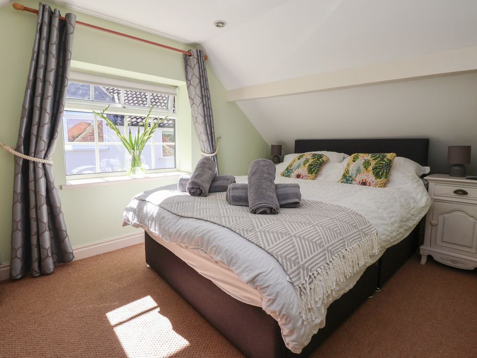 A bedroom with a bed and towels at Figgy Cottage in Ripon