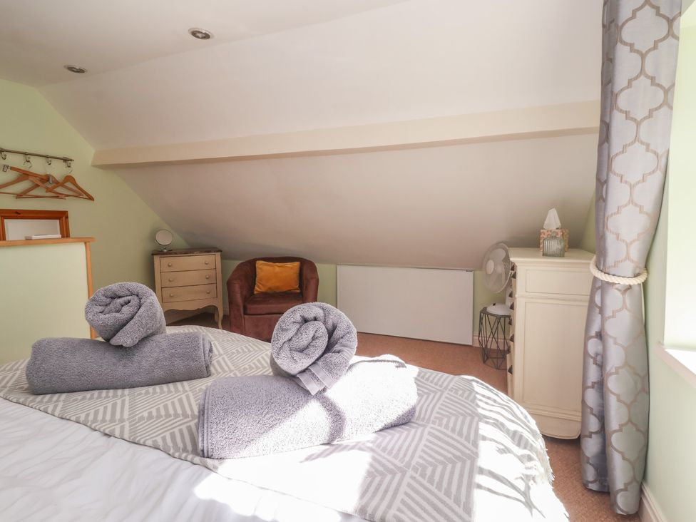 A bedroom with towels on the bed at Figgy Cottage in Ripon