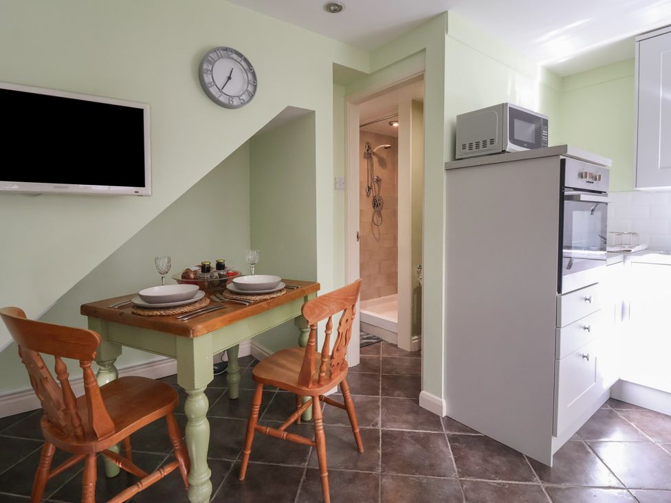 A kitchen with a table and chairs at Figgy Cottage in Ripon
