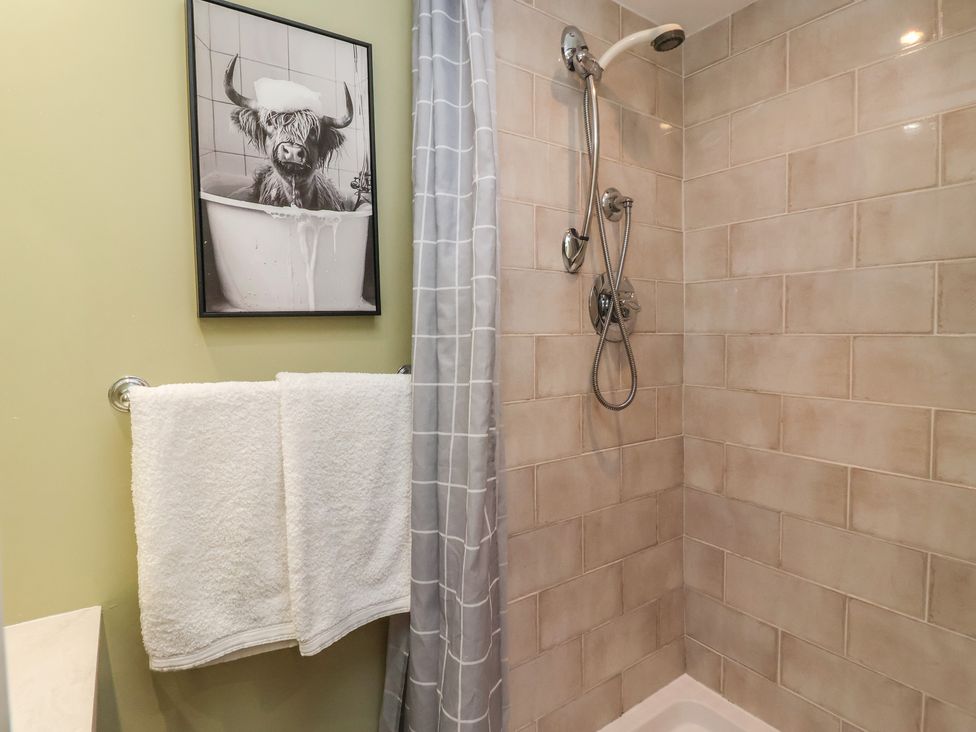 A shower with towels in a bathroom at Figgy Cottage in Ripon