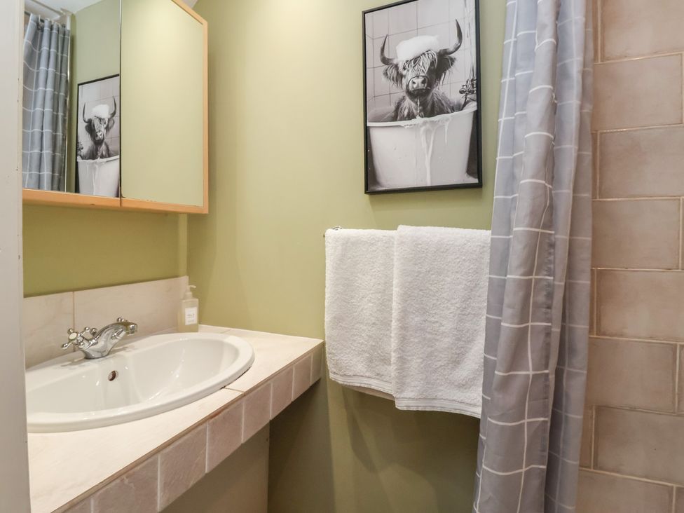 A bathroom with a sink and mirror at Figgy Cottage in Ripon