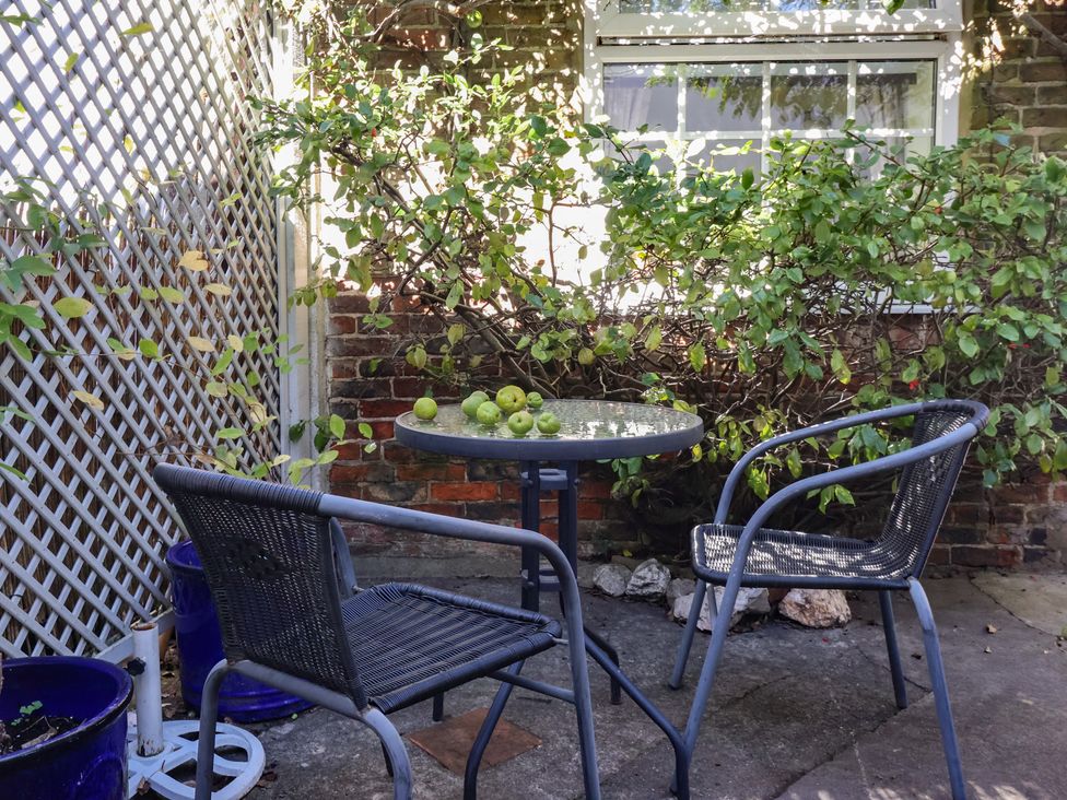 A table with green apples and two chairs at Figgy Cottage in Ripon