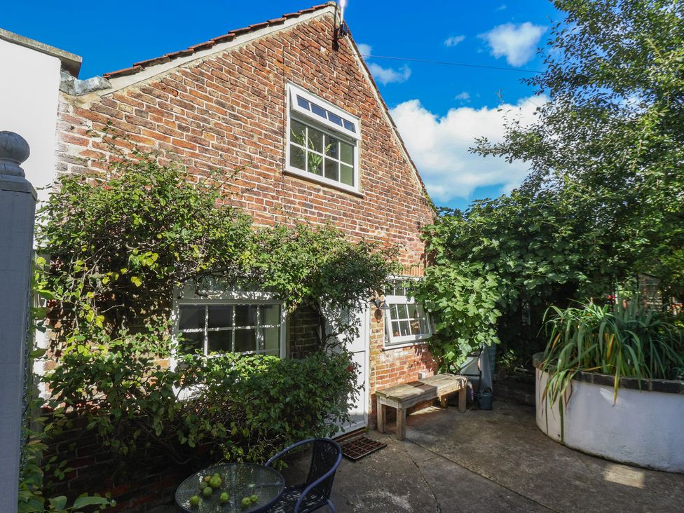An outdoor area with a bench and table at Figgy Cottage in Ripon