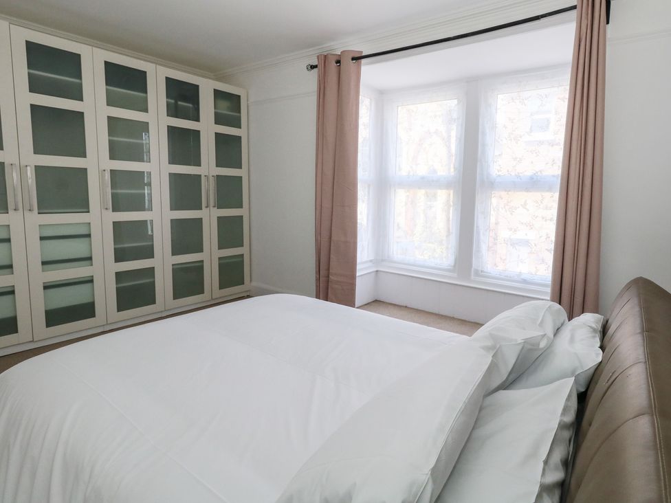 A bedroom with a bed and wardrobe at Weymouth Seaside House in Weymouth