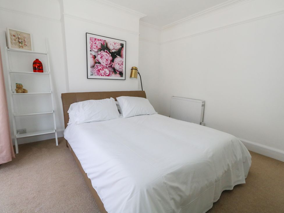 A bedroom with a bed and shelf at Weymouth Seaside House in Weymouth