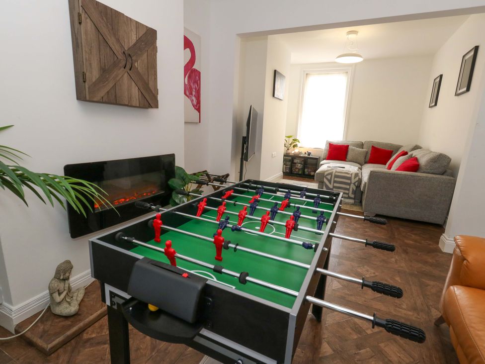 A living room with foosball table and sofa at Weymouth Seaside House in Weymouth