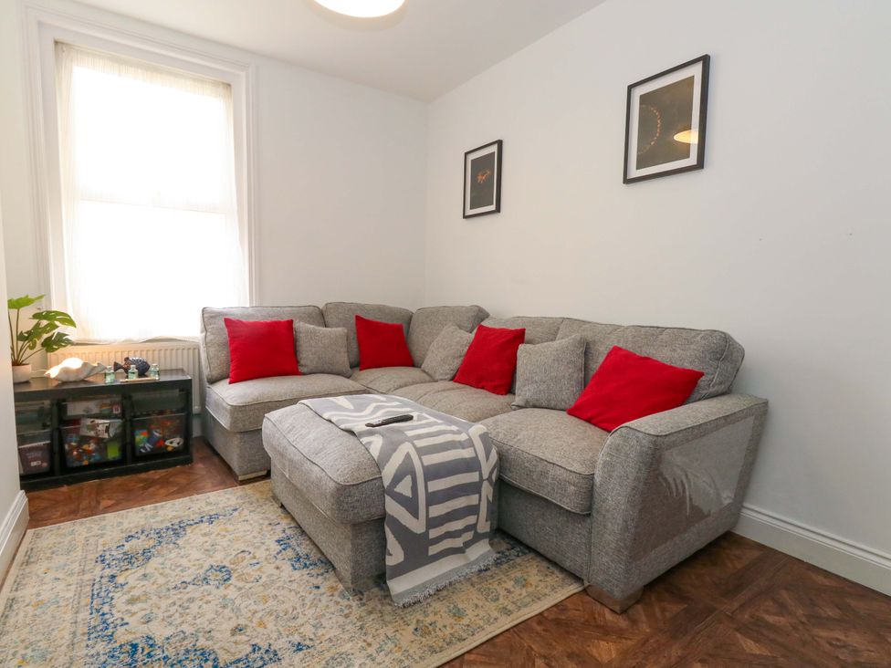 A living room with a sofa and cushions at Weymouth Seaside House in Weymouth