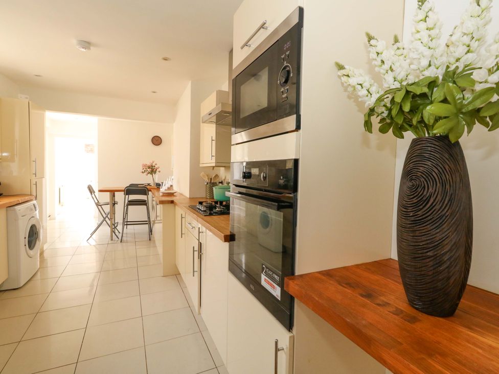 A kitchen with appliances and a dining table at Weymouth Seaside House, Weymouth
