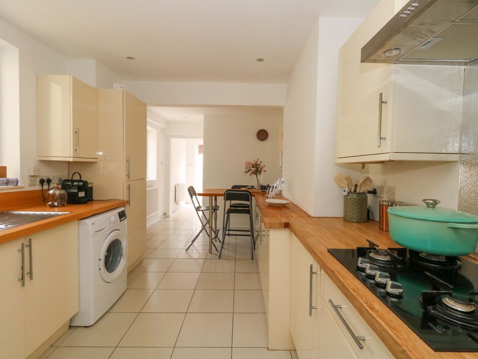 A kitchen with appliances and a table at Weymouth Seaside House in Weymouth