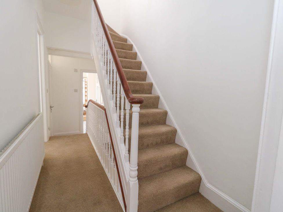 A hallway with stairs and a handrail at Weymouth Seaside House in Weymouth