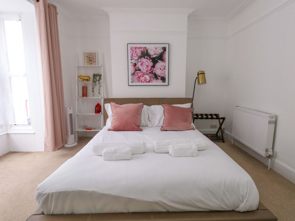 A bedroom with a bed and wall art at Weymouth Seaside House in Weymouth