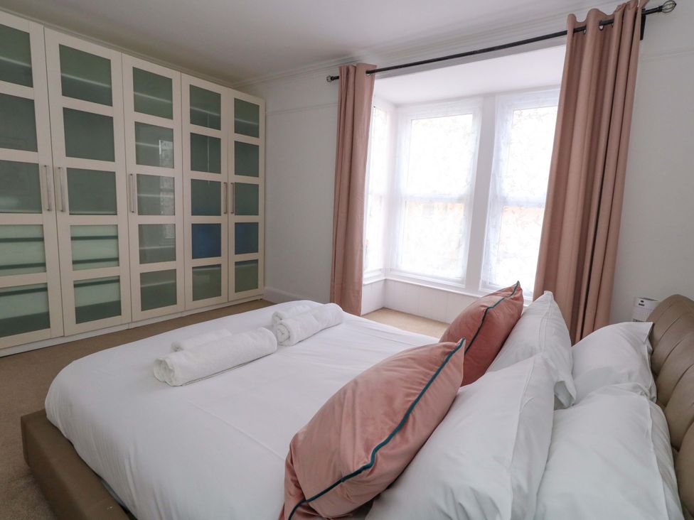 A bedroom with a bed and wardrobe at Weymouth Seaside House in Weymouth