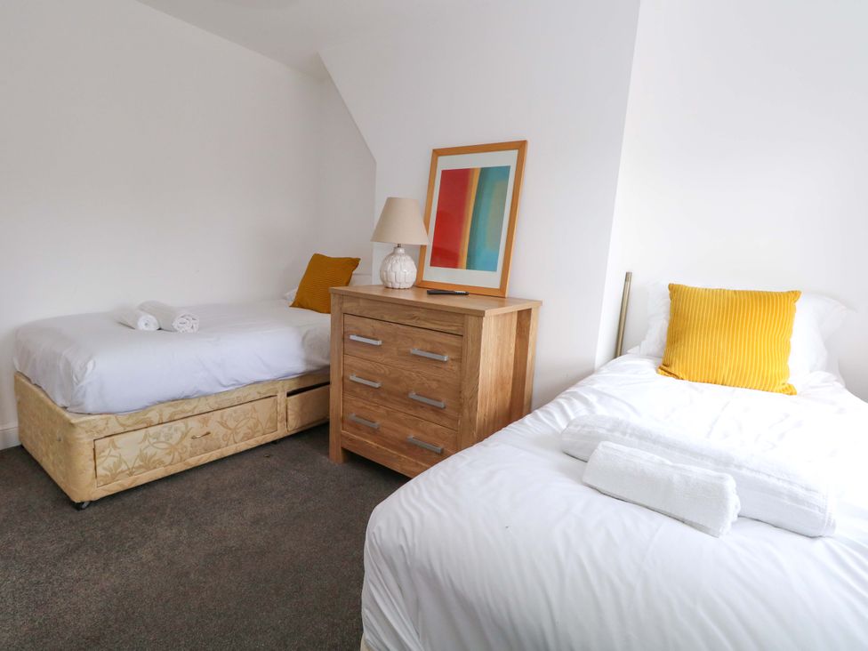 A bedroom with two beds and a drawer unit at Weymouth Seaside House in Weymouth