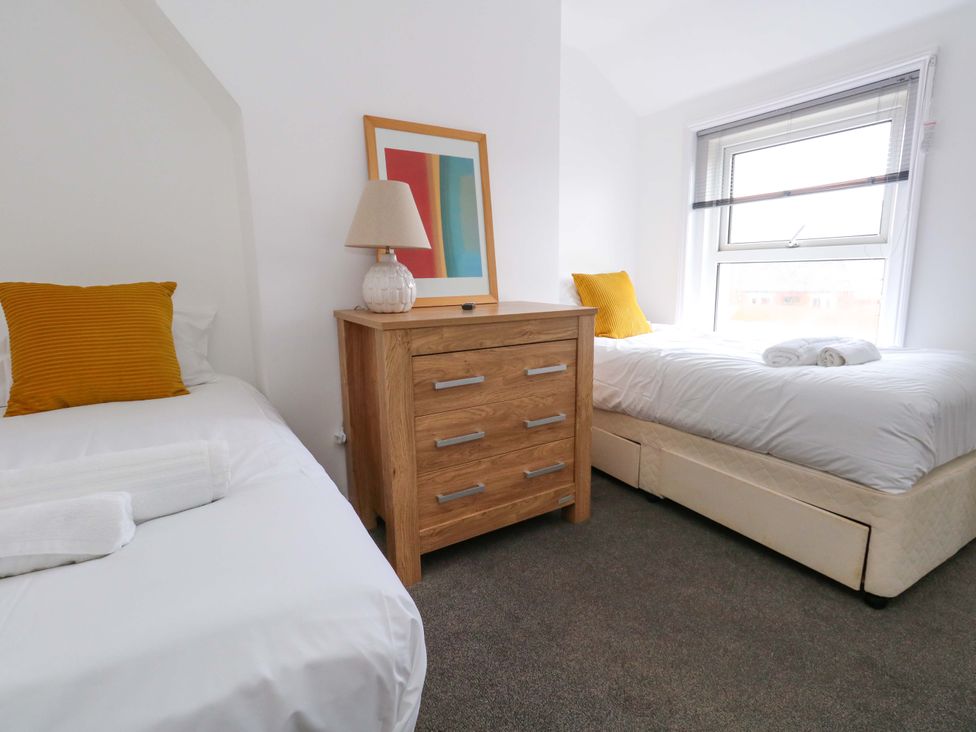 A bedroom with two beds and a dresser at Weymouth Seaside House in Weymouth