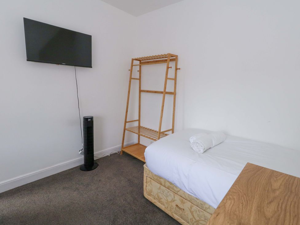 A bedroom with a bed and a television at Weymouth Seaside House in Weymouth