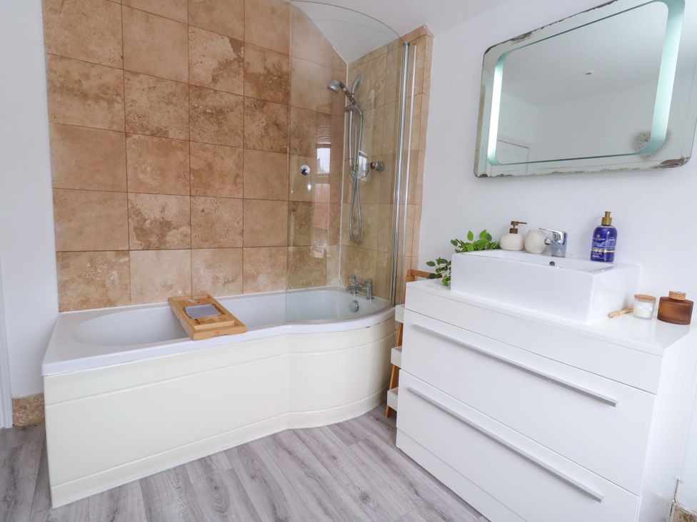A bathroom with a bathtub and sink at Weymouth Seaside House in Weymouth