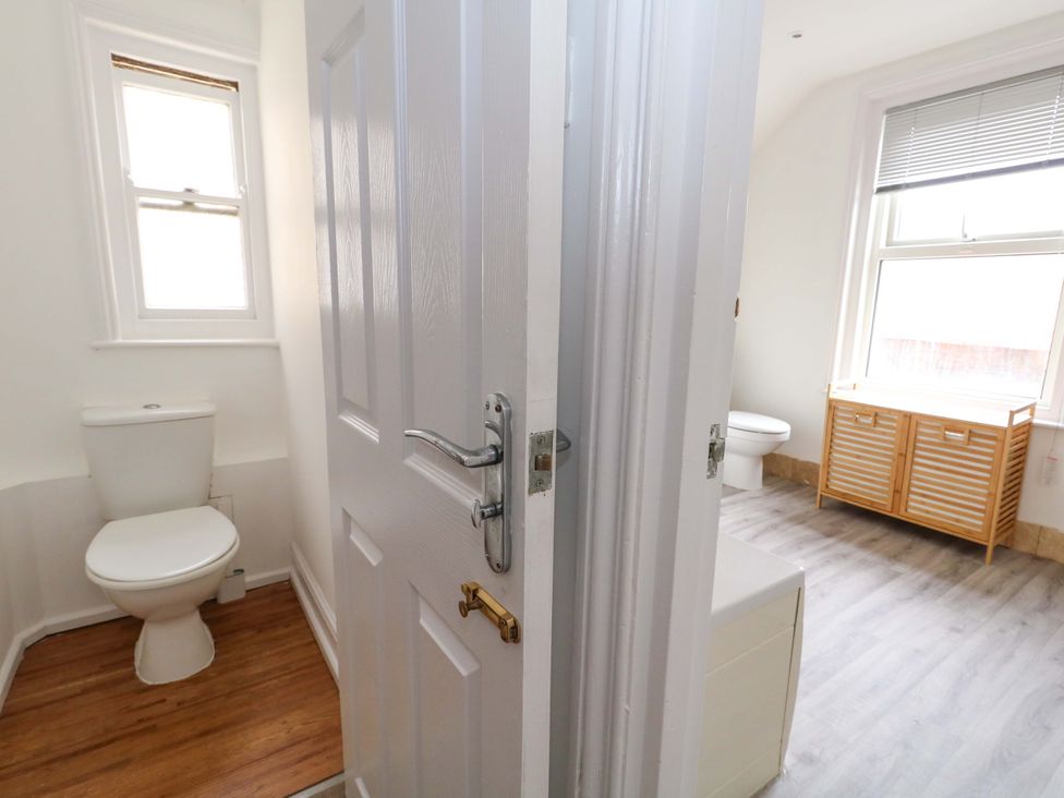 A bathroom with a toilet and cabinet at Weymouth Seaside House in Weymouth