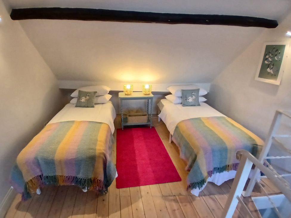 A bedroom with two beds and a nightstand at Harbourside in Weymouth