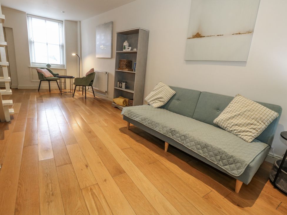 A living room with a sofa and armchairs at Harbourside in Weymouth