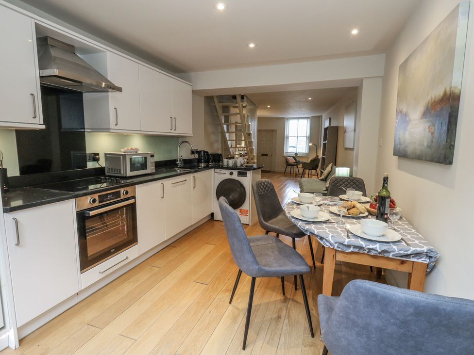 A kitchen with appliances and a dining table at Harbourside in Weymouth