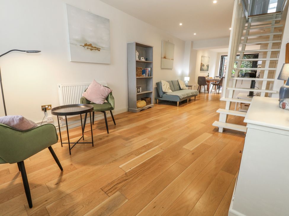 A living room with a sofa, armchairs, and a dining table at Harbourside in Weymouth