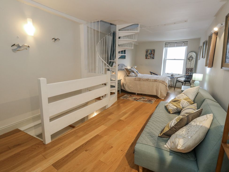 A bedroom with a spiral staircase and a bed at Harbourside, Weymouth