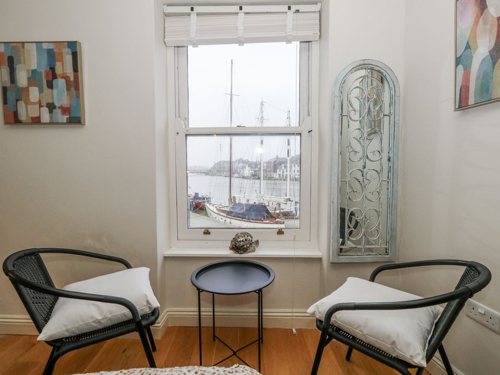A seating area with a window view of boats at Harbourside in Weymouth
