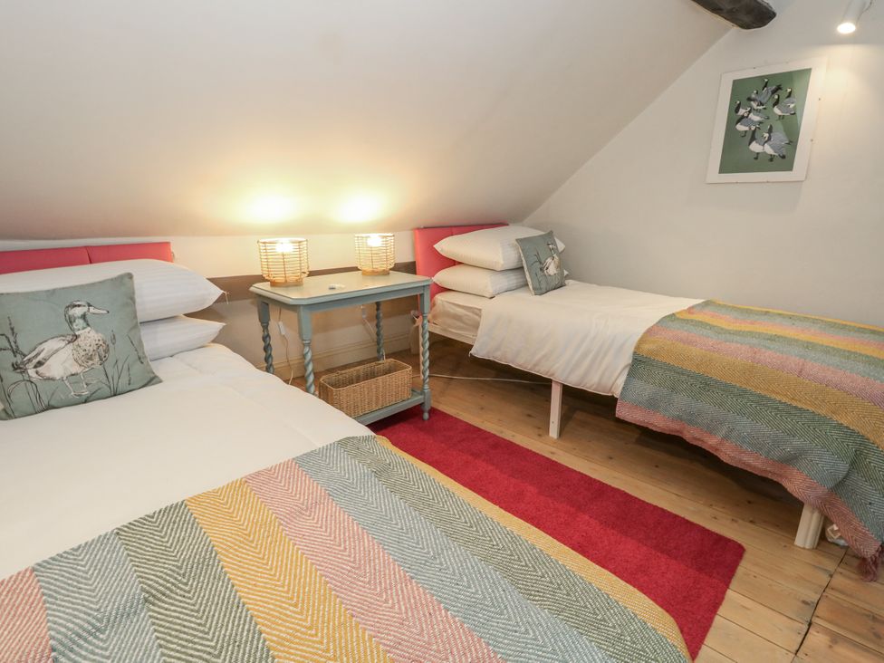A bedroom with two beds and a bedside table at Harbourside in Weymouth